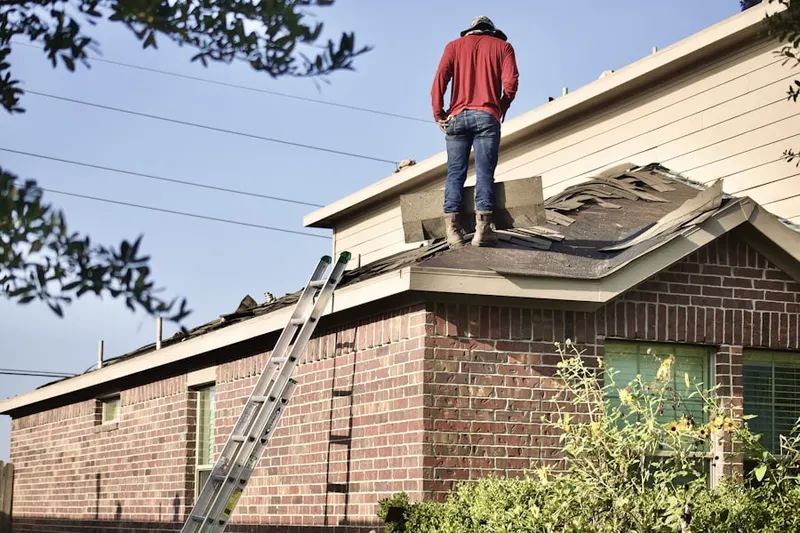 Professional roofer working on a residential roof in Peters